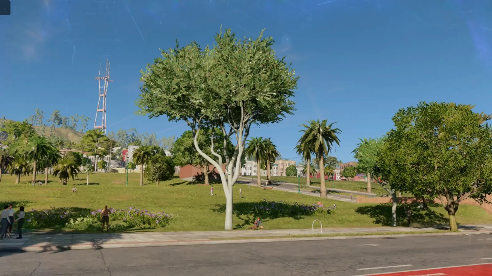A pale branching tree stands in a grassy park before a hill, with a slender red mast rising above the trees and palms, paths, flowers, and low buildings nearby.